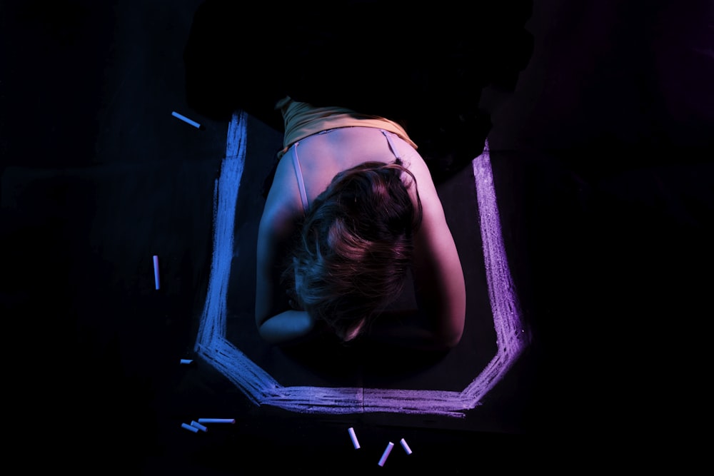 a woman laying down in a mirror in the dark