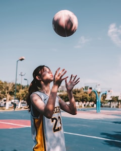 a basketball player reaching up to grab the ball