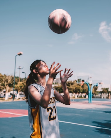 a basketball player reaching up to grab the ball
