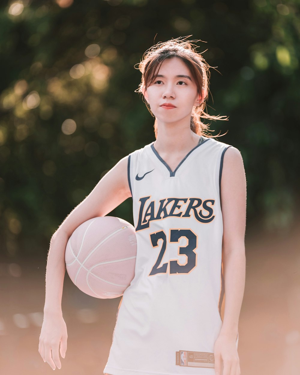 a young woman holding a basketball on a court