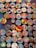 A collection of colorful, circular art pieces each featuring unique designs and patterns. The designs include abstract shapes, animals, people, and cultural motifs, with bold and varied color schemes.