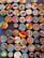 A collection of colorful, circular art pieces each featuring unique designs and patterns. The designs include abstract shapes, animals, people, and cultural motifs, with bold and varied color schemes.