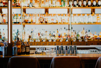 A well-stocked bar with a bartender preparing cocktails.