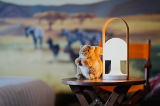 Minimalist storybook scene featuring block-like animals softly illuminated by warm amber light.