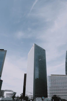 A professional reviewing real estate blueprints with a city skyline in the background.