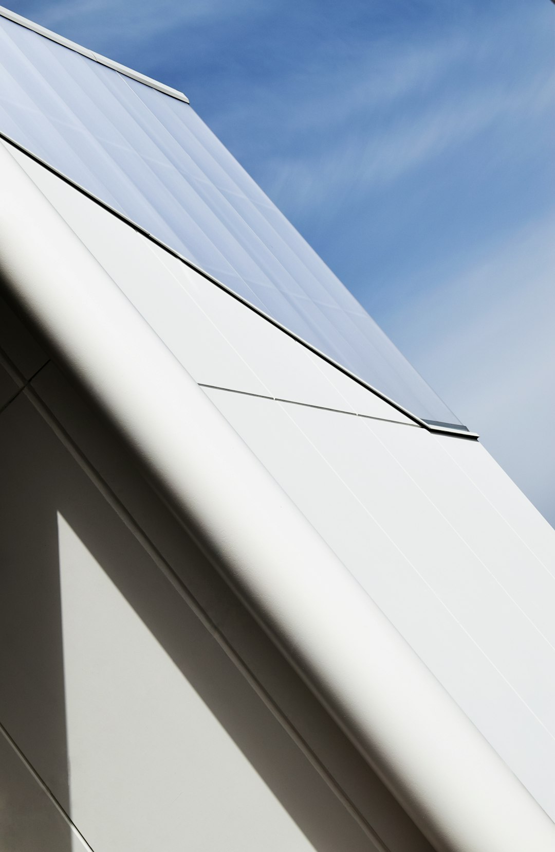 white concrete high-rise building under blue and white skies