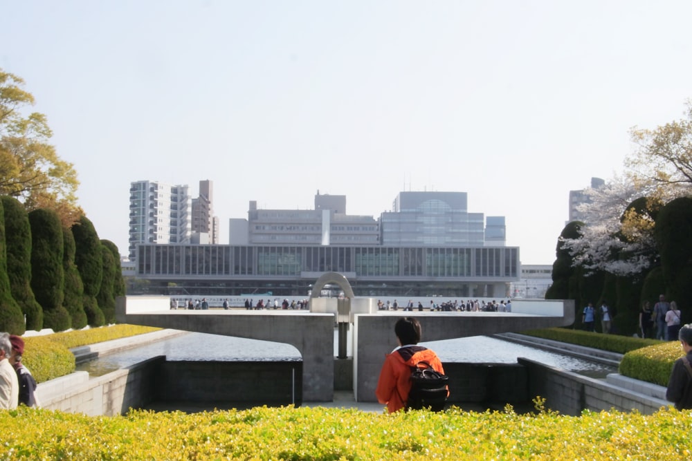 person in orange jacket standing at the garden