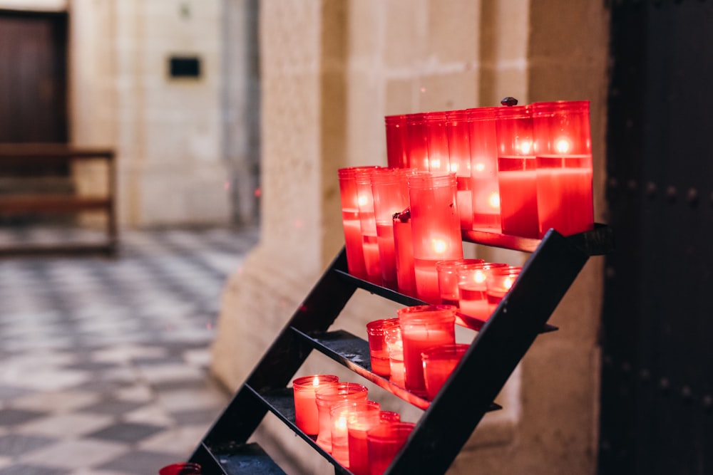 Candelabros de vidrio rojo sobre estante negro