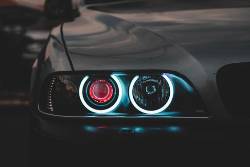 Close-up of a car headlight with glowing blue circular rings and red center