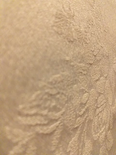 Close-up of a pastel teal and pink embroidered floral pattern on soft fabric