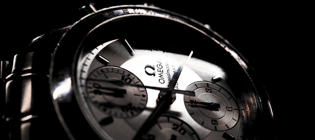 round silver-colored Omega chronograph watch