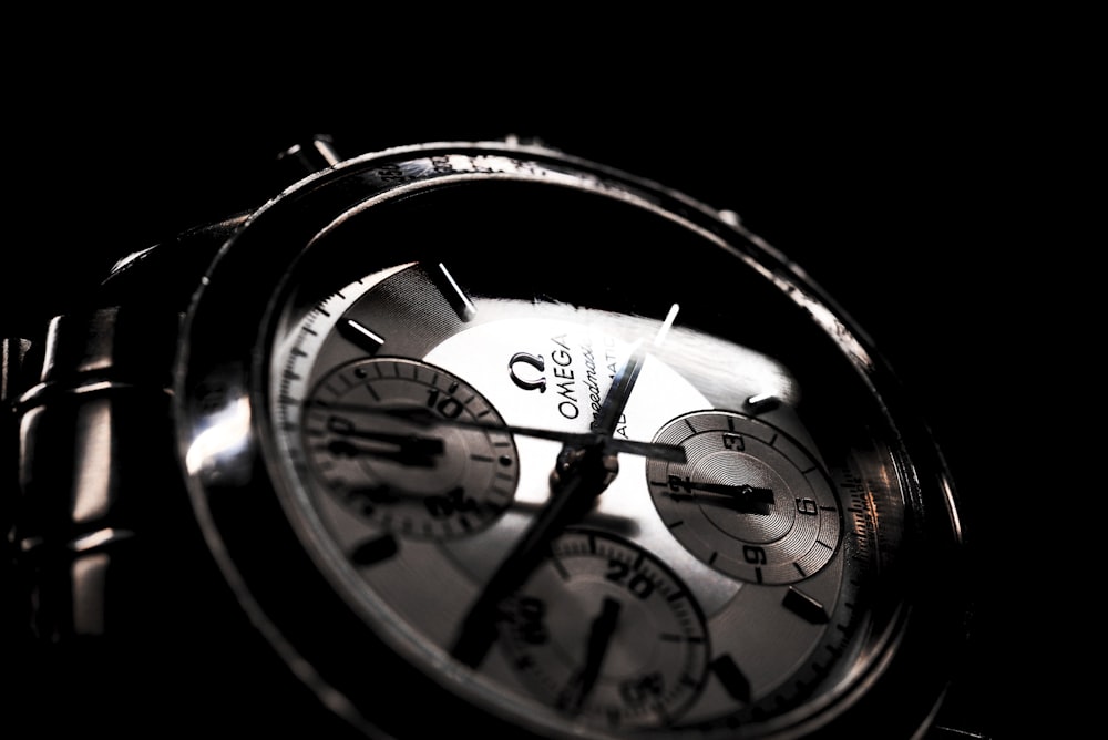 round silver-colored Omega chronograph watch