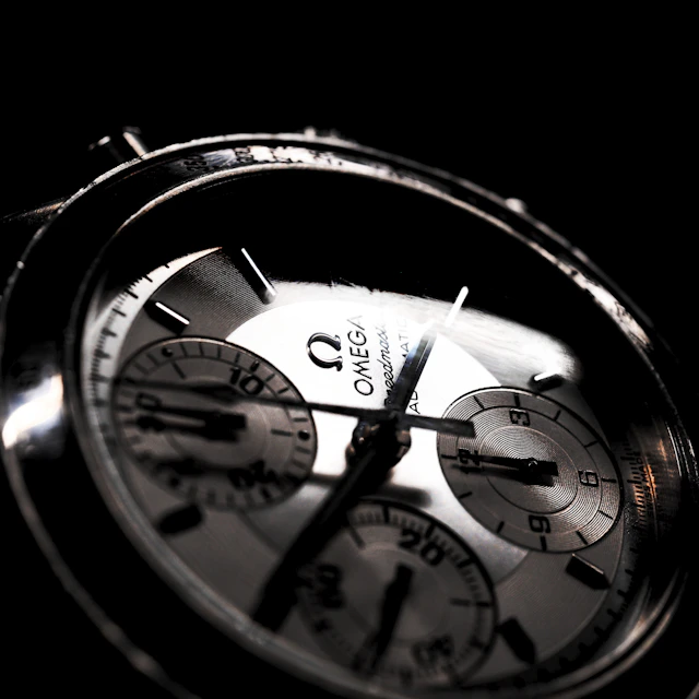 A round silver Omega chronograph watch shown up close