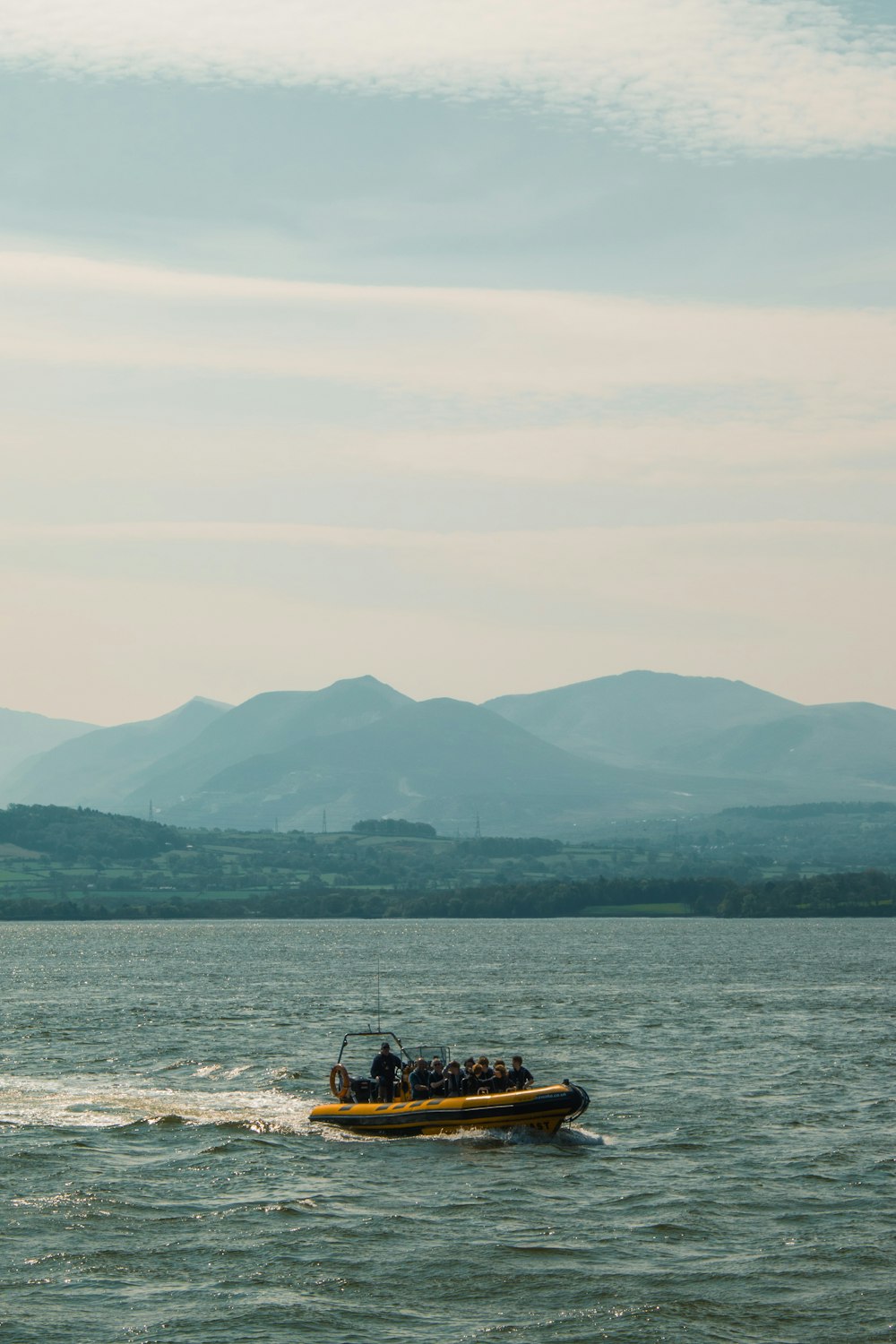 people riding yellow boat viewing mountain