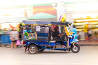 A tuk tuk weaving through the lively streets of Madrid, passing by iconic landmarks.