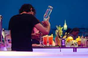 man in black t-shirt preparing tequila at the counter