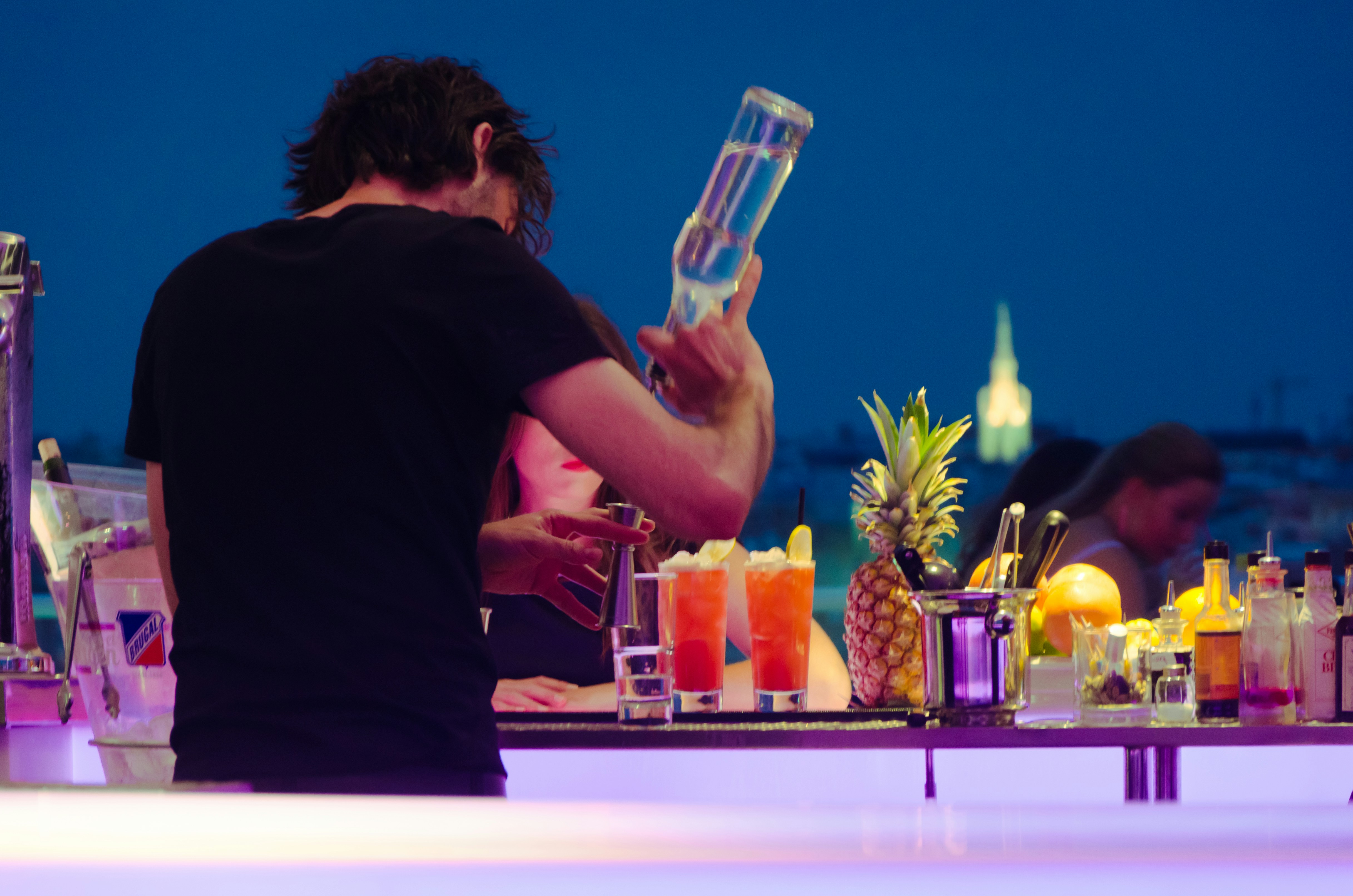 Bartender making a drink at a rooftop bar in Madrid.