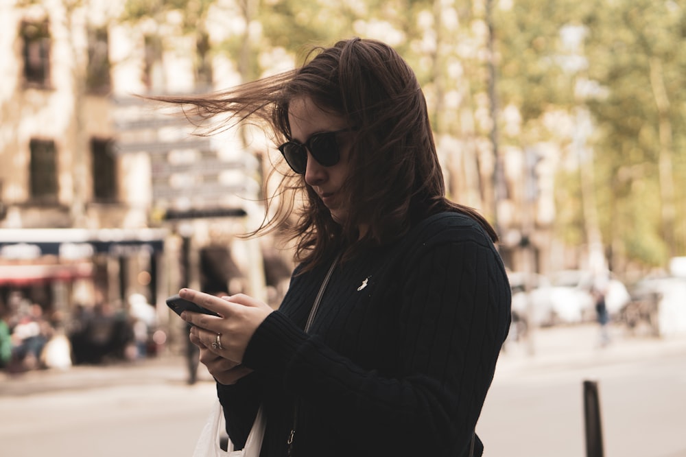 woman standing and using phone hone