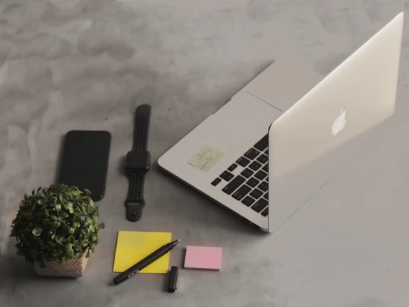 Modern office workspace with a laptop, smartphone, and digital planner on a clean desk.
