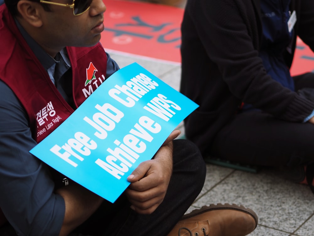 man holding free job change achieve WPS signage