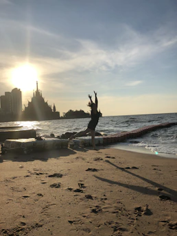 A traveler joyfully walking along a sunlit beach at sunset, capturing the warm essence of a perfect getaway.