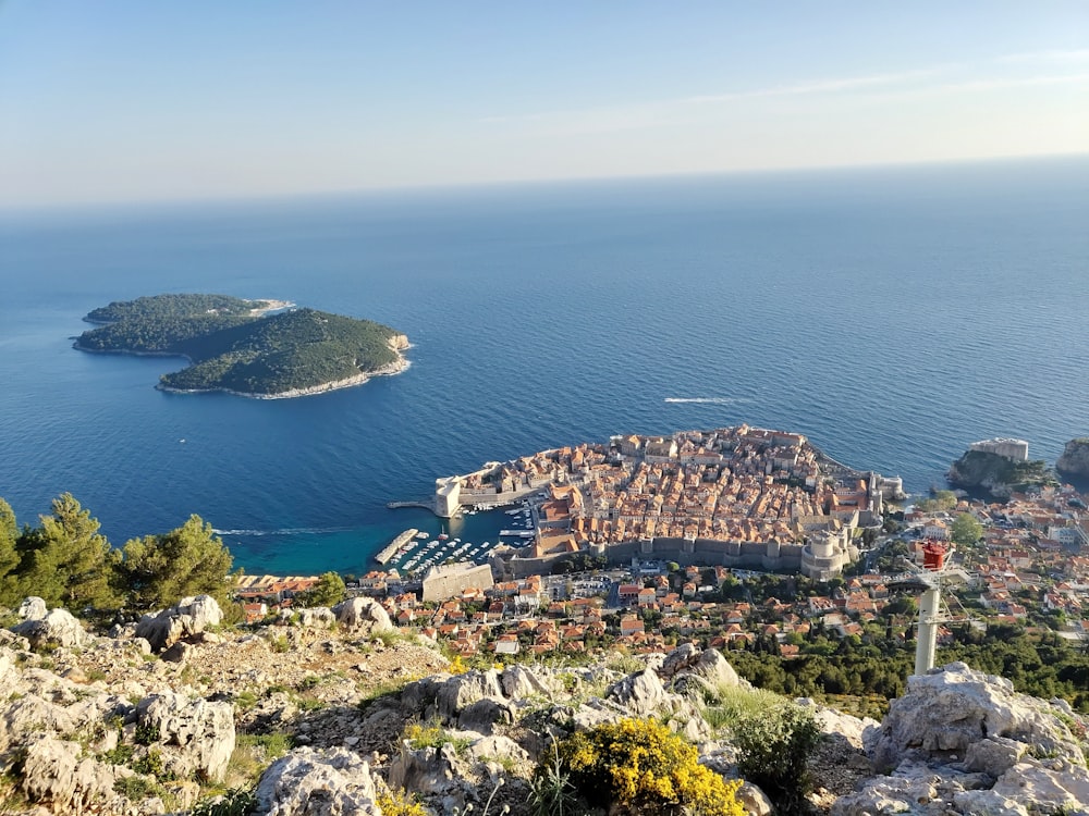 island, body of water, and village in aerial view at daytime