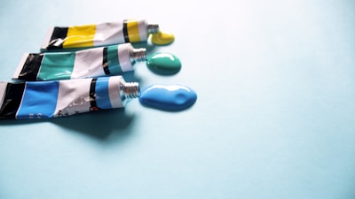 Bright yellow and green adhesive tubes arranged artistically on a workshop table.