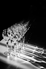 Close-up of elegant arch aluminum frames paired with delicate glass wine cups on a wooden table.