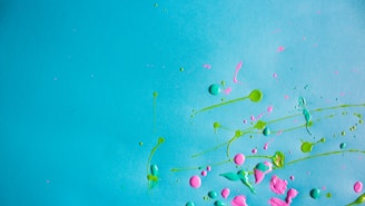 Colorful paint splats in bright teal and neon hues, representing creativity and expression.