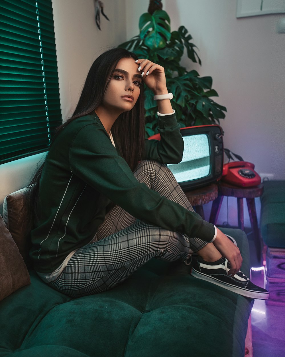 woman sitting on tufted couch beside TV