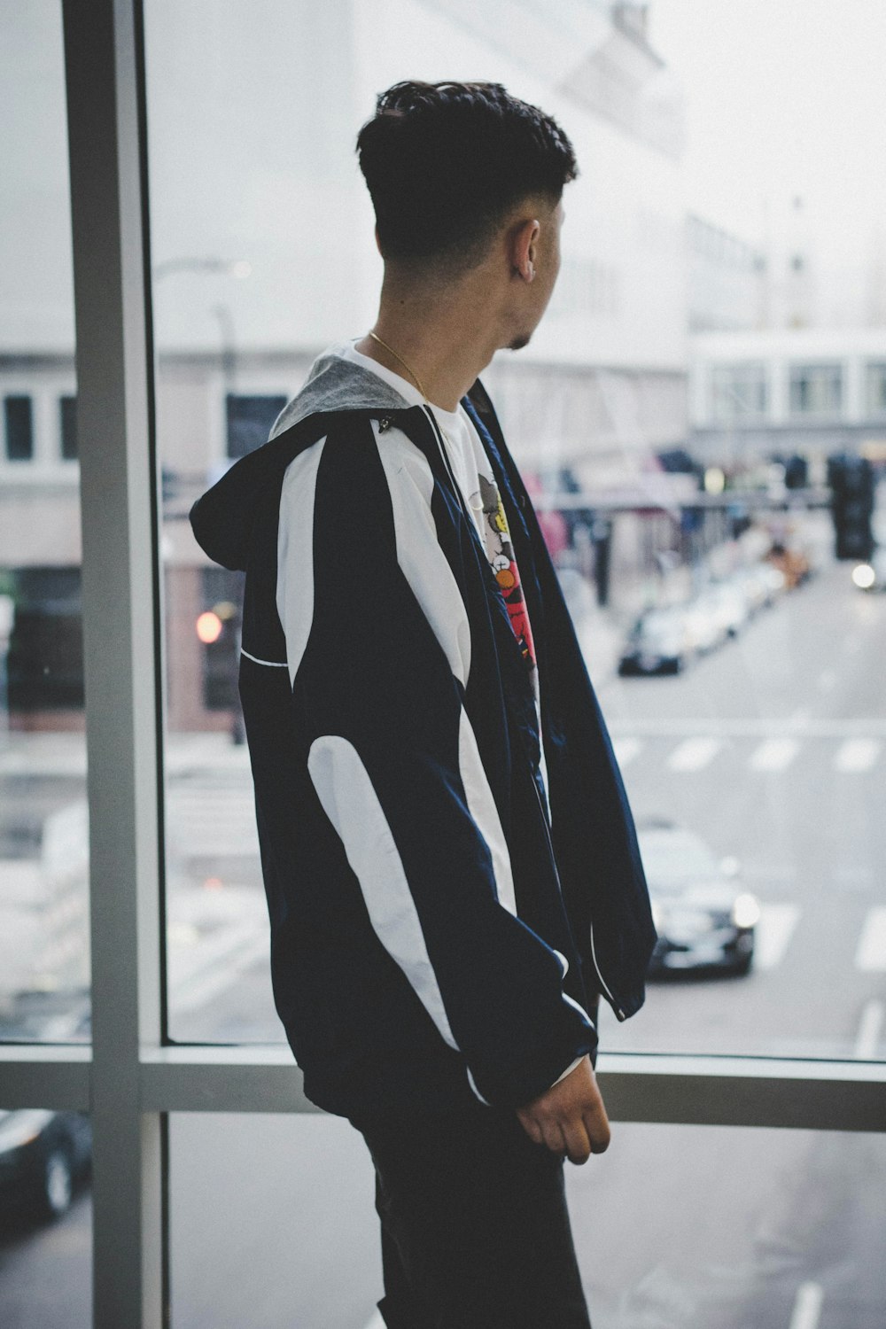 man standing beside glass window