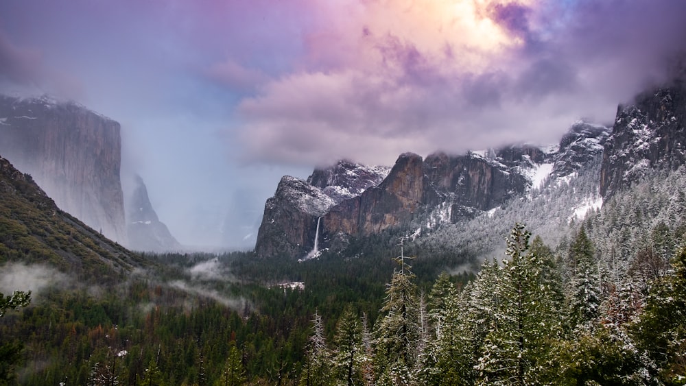 montaña cubierta de nieve bajo nubes grises durante el día