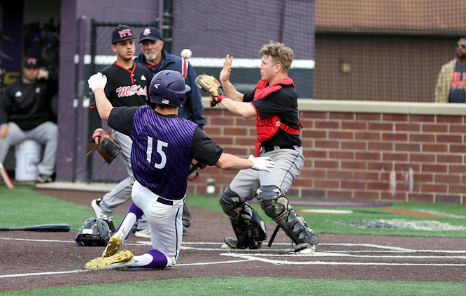 Action shot of the Ball Busters team sliding into home base under stadium lights with black and blue uniforms.