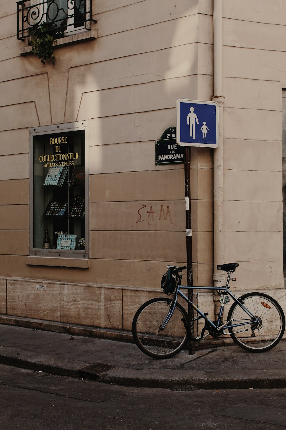 gray bicycle leaning on brown wall