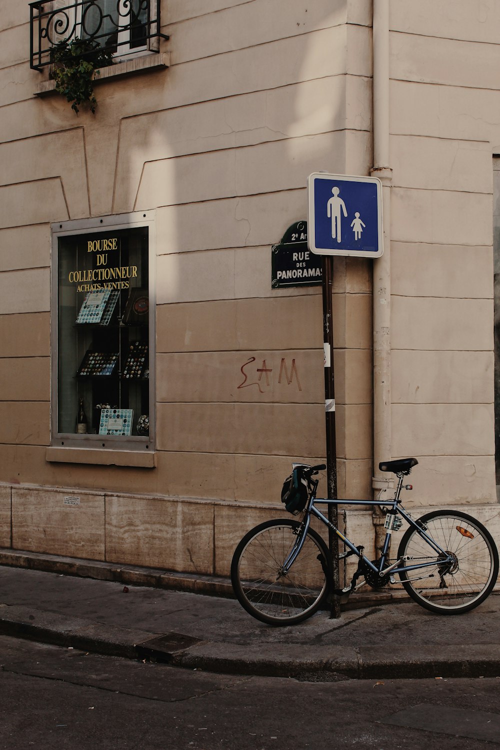bicicletta grigia appoggiata al muro marrone