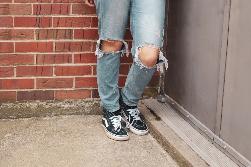 person wearing blue distressed denim jeans