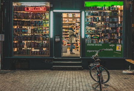 A friendly local shop owner welcoming customers in a neighborhood store.