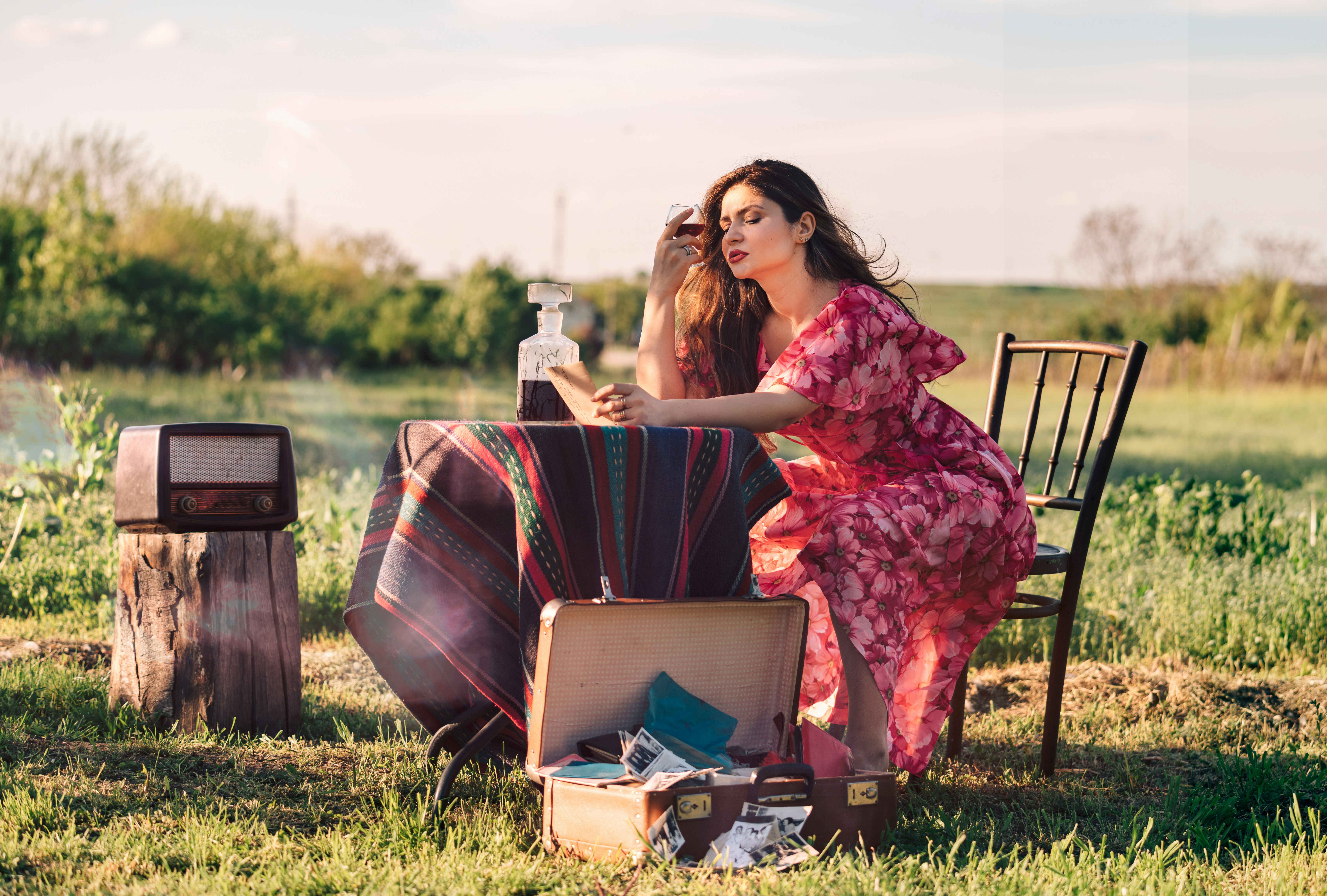 woman sitting at table holding wine glass