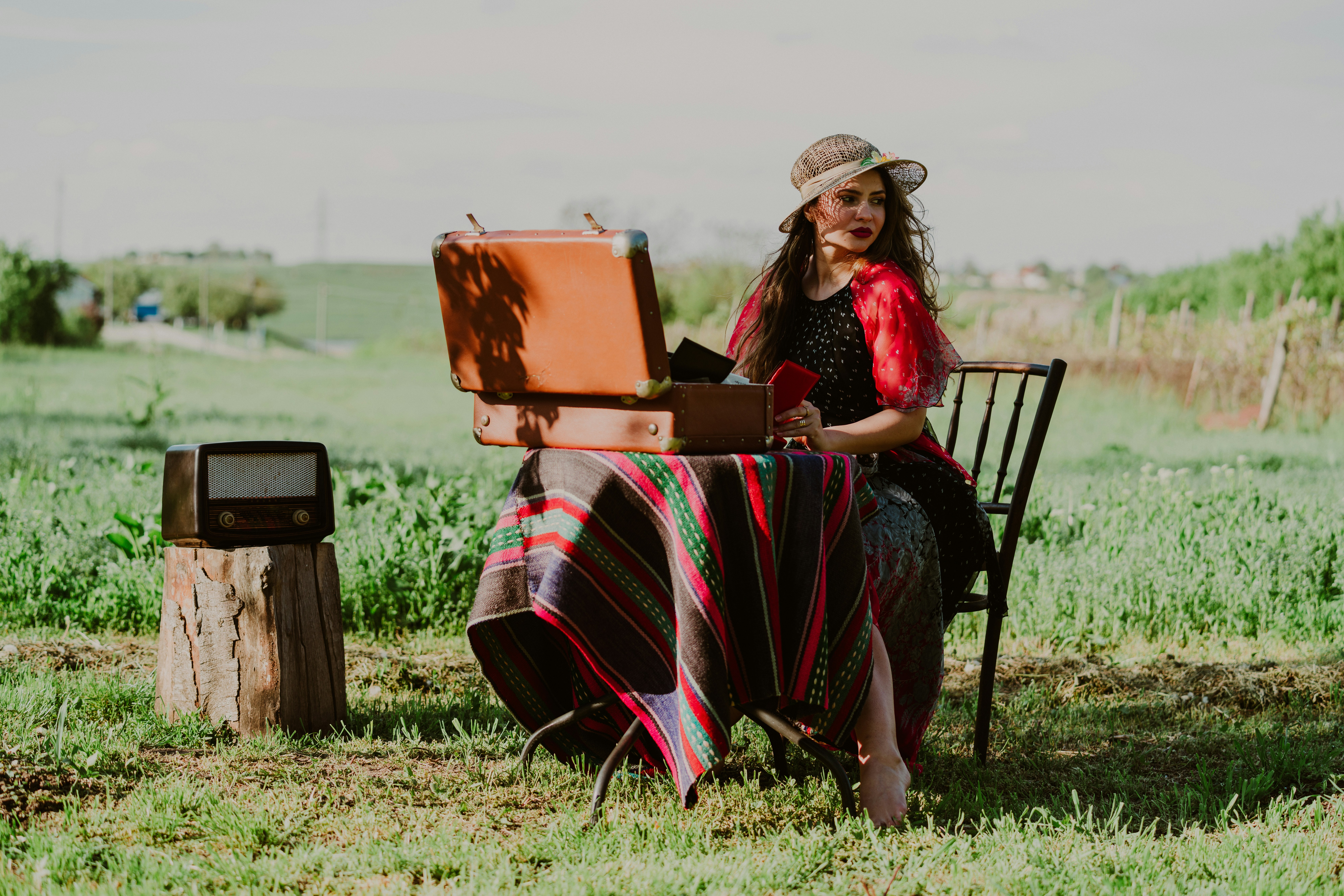 woman sitting near table in green field