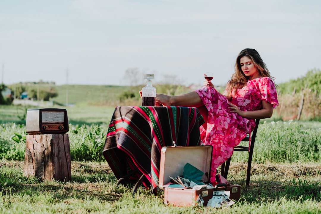 woman in pink and white floral dress sitting beside table