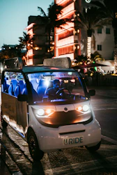 A vibrant street scene featuring several electric vehicles parked near a government building.