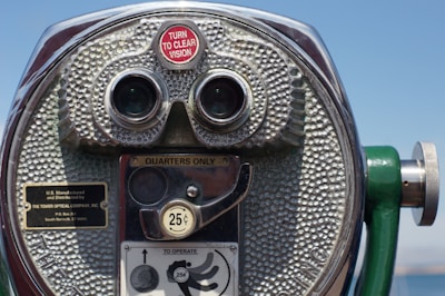 Close-up of vintage photo booth coin slot with a hand inserting a coin.
