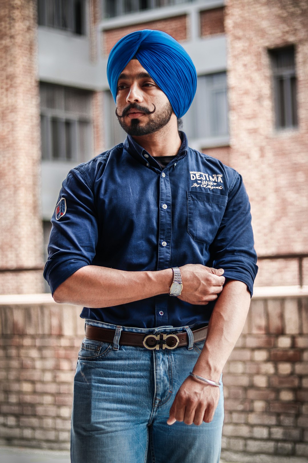 man wearing blue denim dress shirt and blue turban standing