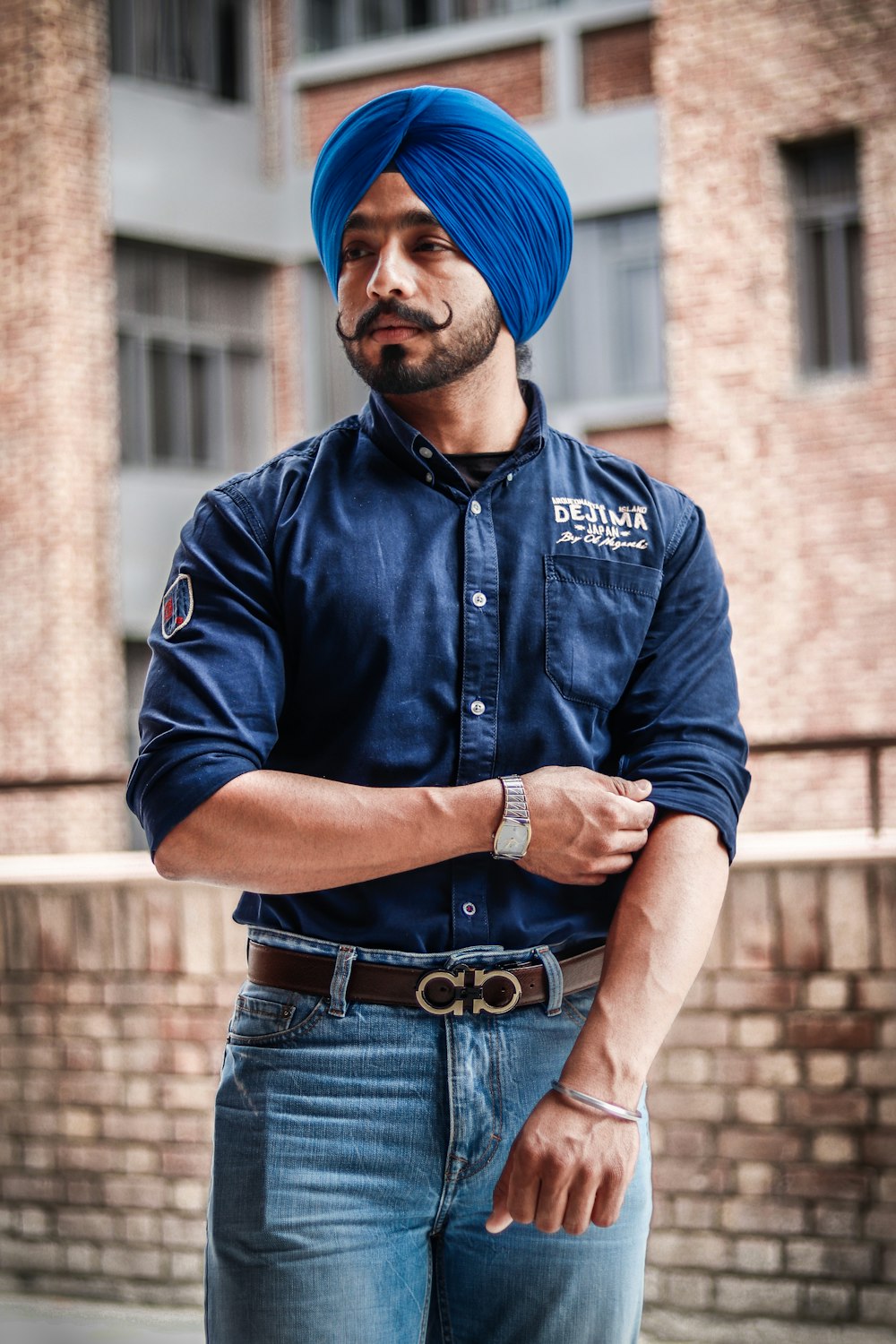 man wearing blue denim dress shirt and blue turban standing