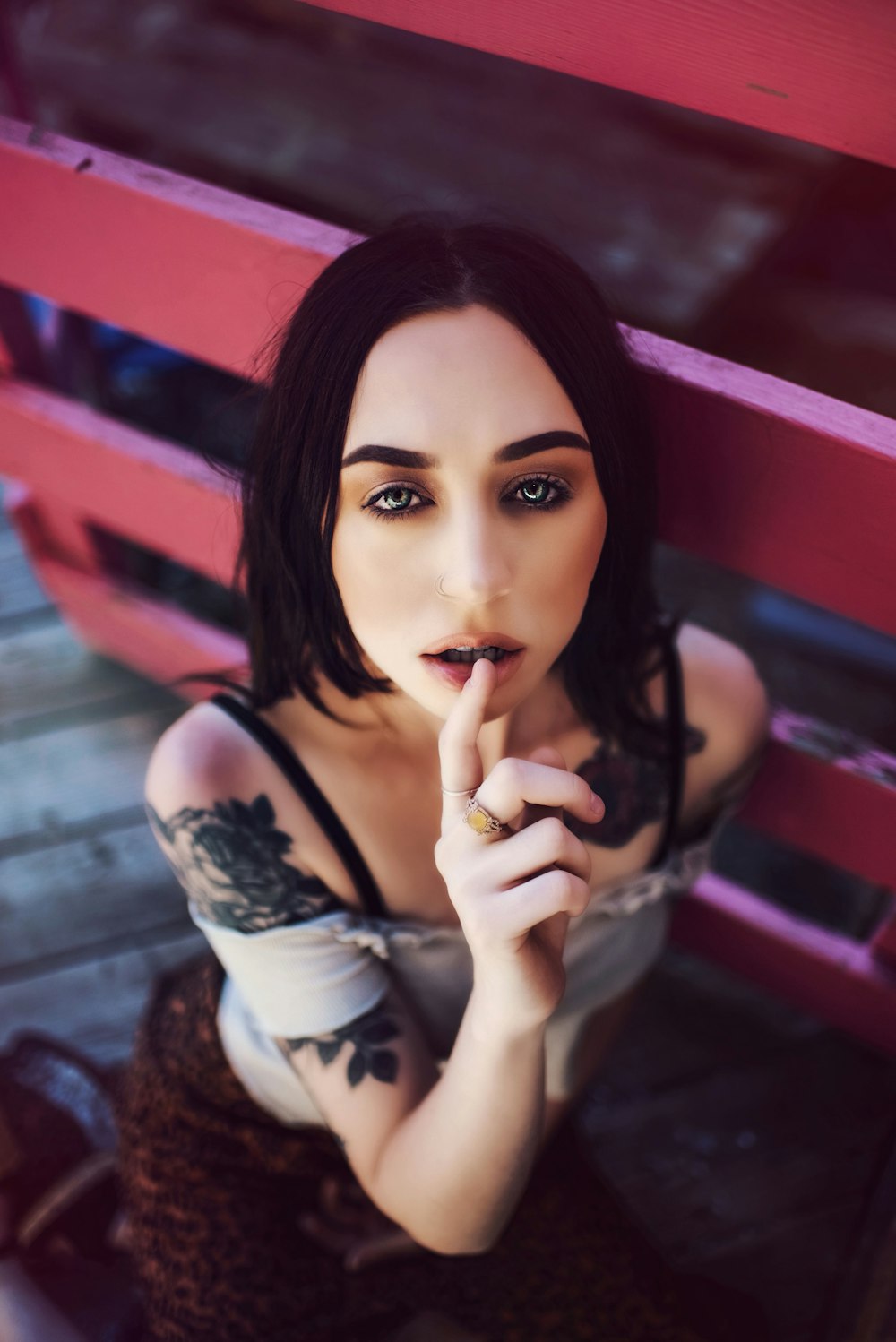 woman wearing white strapless crop top besides red wooden gate