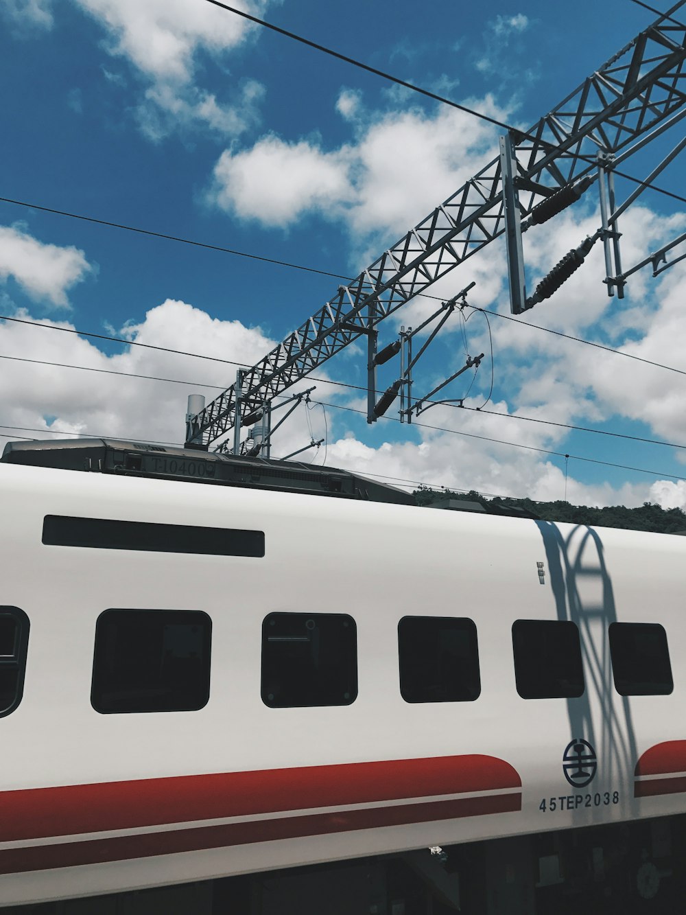 white and red train under blue sky