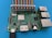 A circuit board with multiple electronic components, featuring ports for USB, HDMI, Ethernet, and power. A colorful ribbon cable is connected to its pins. It's laid on a blue surface.