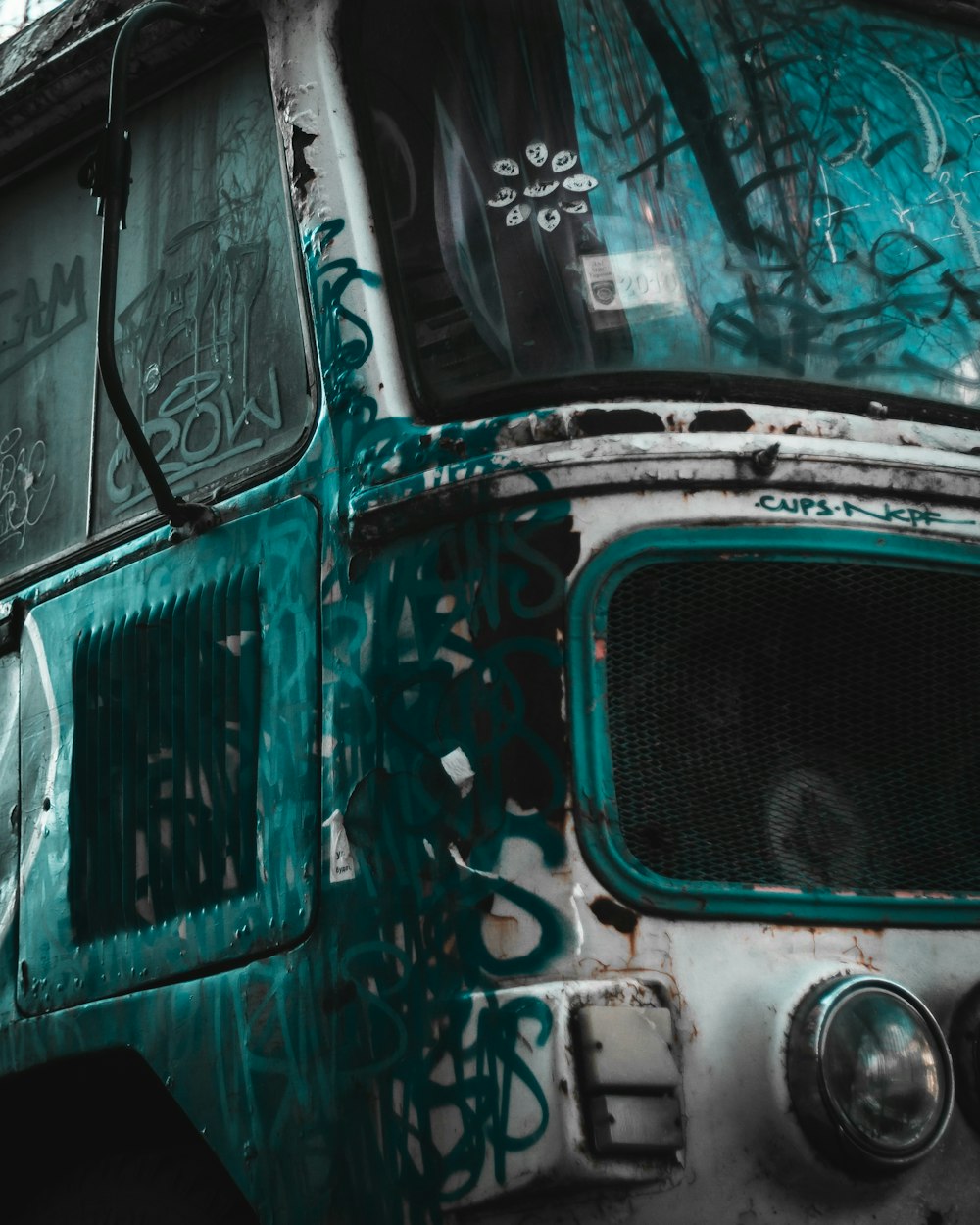 a green and white bus with graffiti on it
