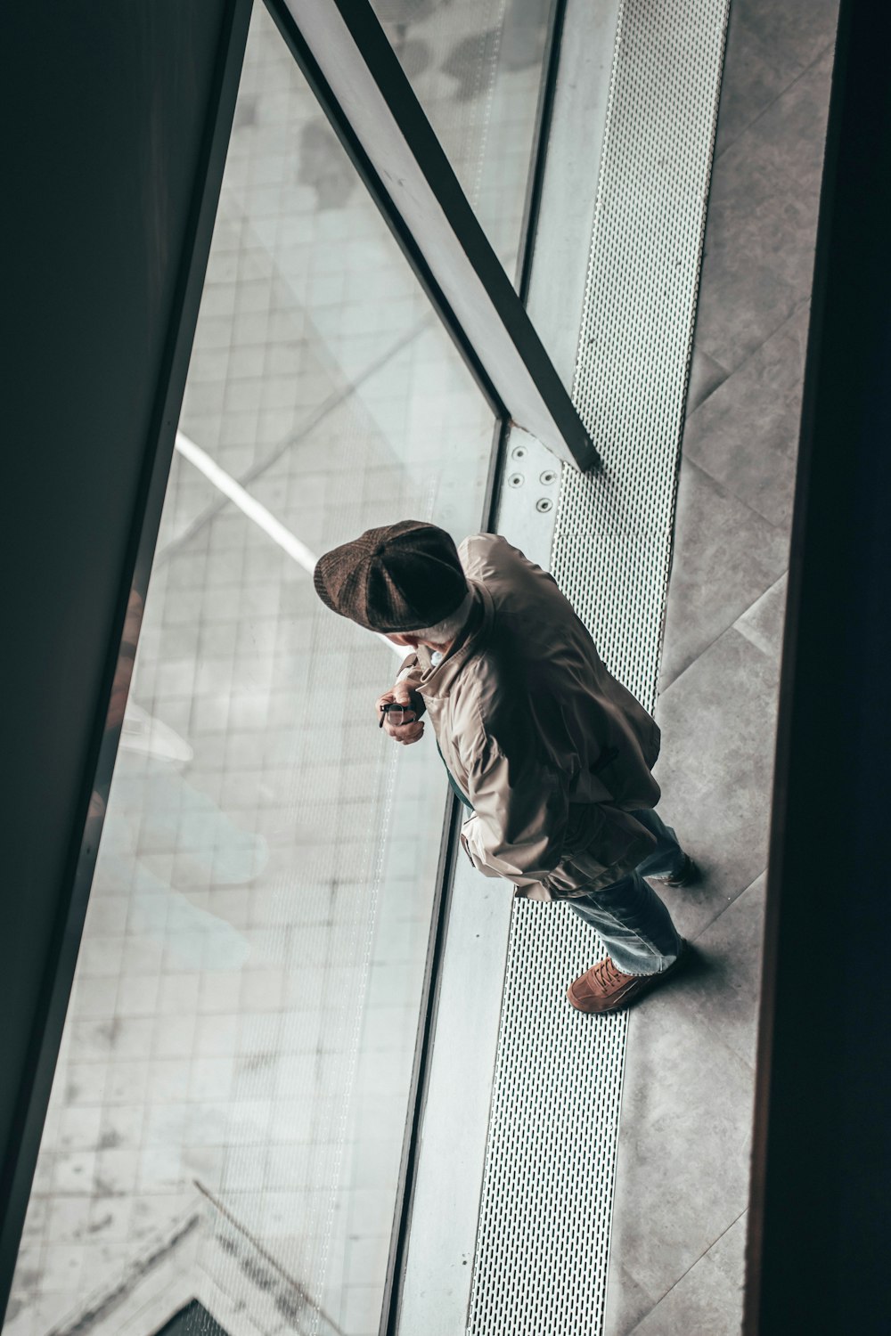 a man standing on a tiled floor next to a window