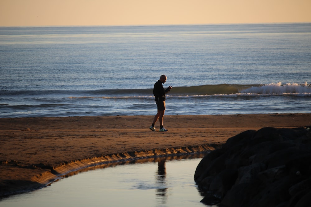 man wearing short standing on shore